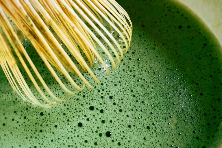 A bamboo whisk (chasen) frothing matcha in a bowl (chawan)