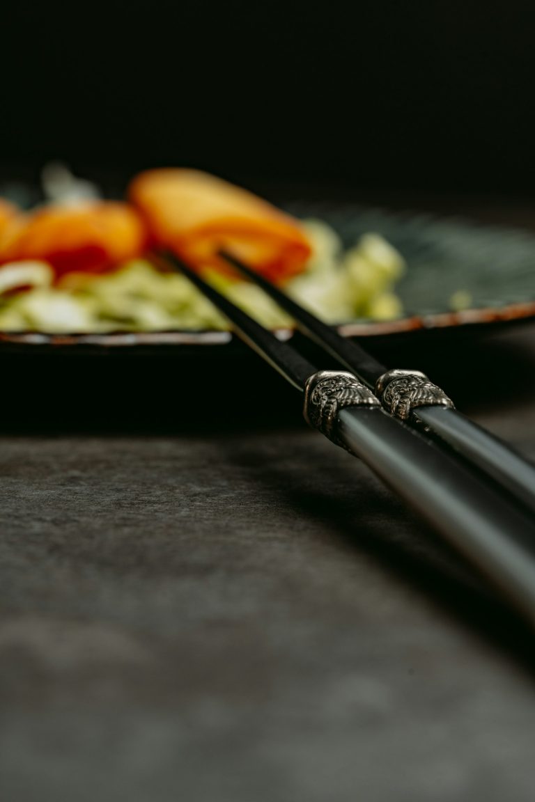 A pair of Japanese chopsticks resting on a plate of food