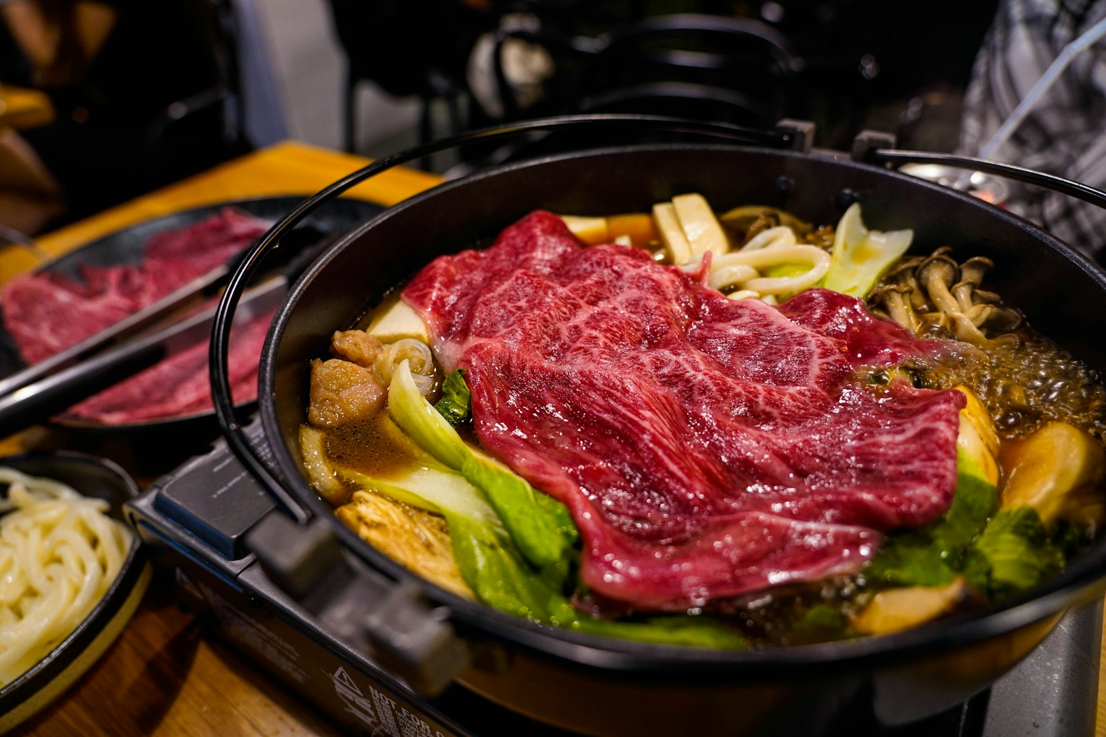 A Japanese nabe hot pot of vegetables and meat simmering in a clay donabe