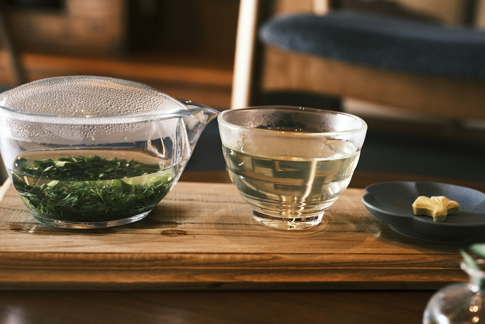 Japanese green tea in a glass pot with cups on a wooden tray